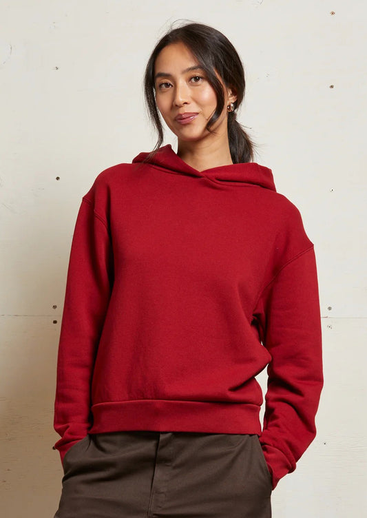 A woman wearing a bright red hoodie sweatshirt.