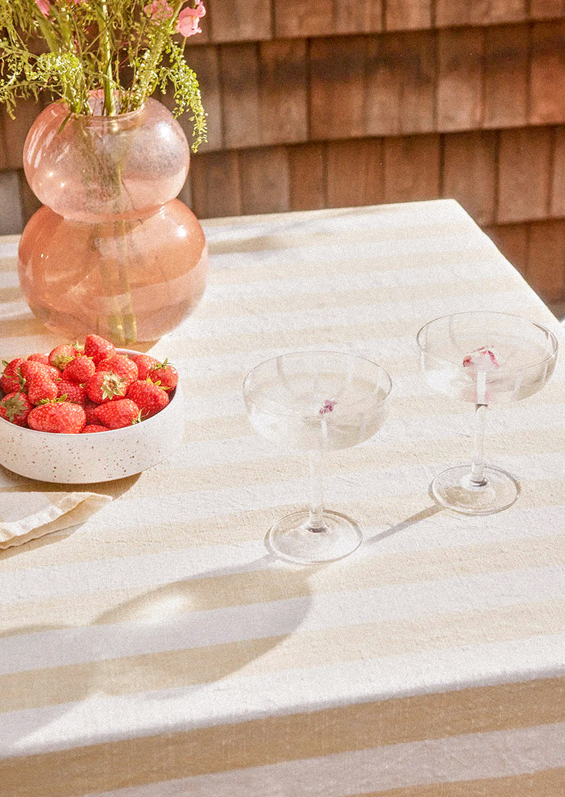 A cotton tablecloth in beige and white stripe pattern.