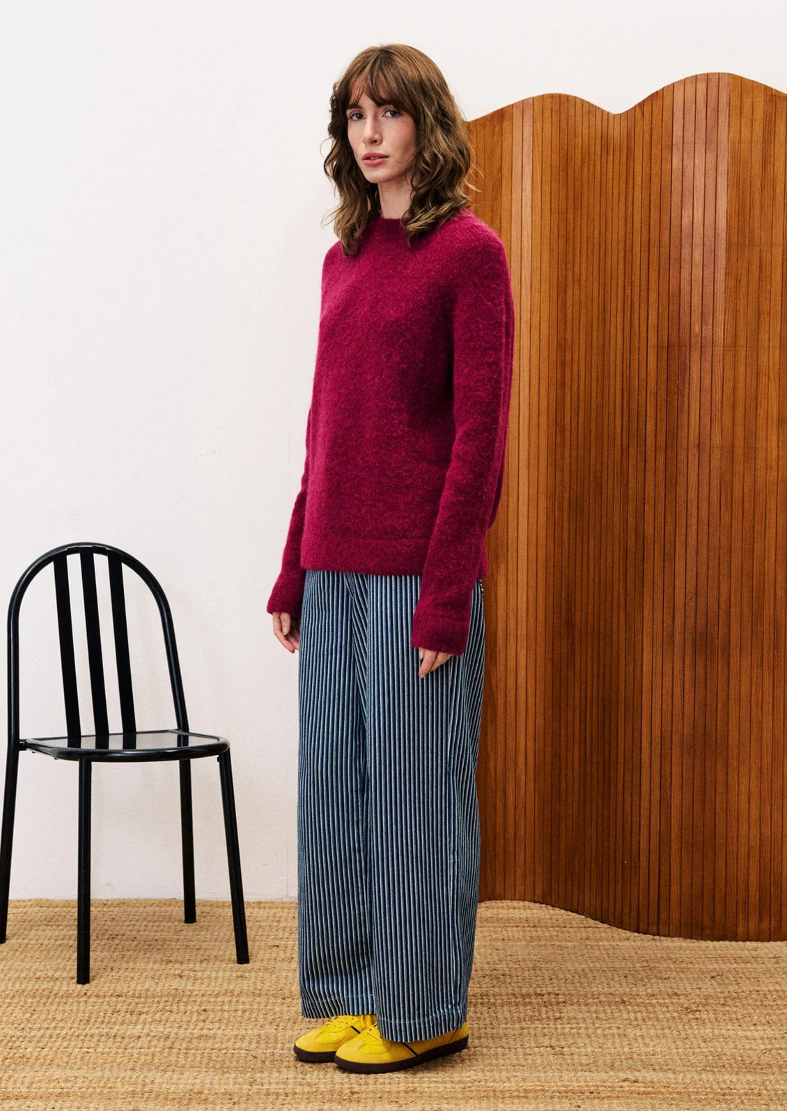 A woman wearing a knit sweater in vibrant burgundy color.