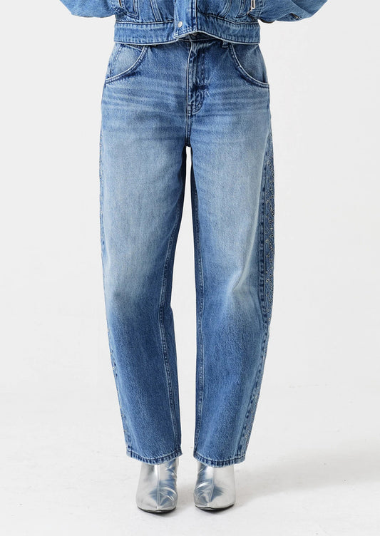 Person wearing blue jeans and a denim jacket on a white background