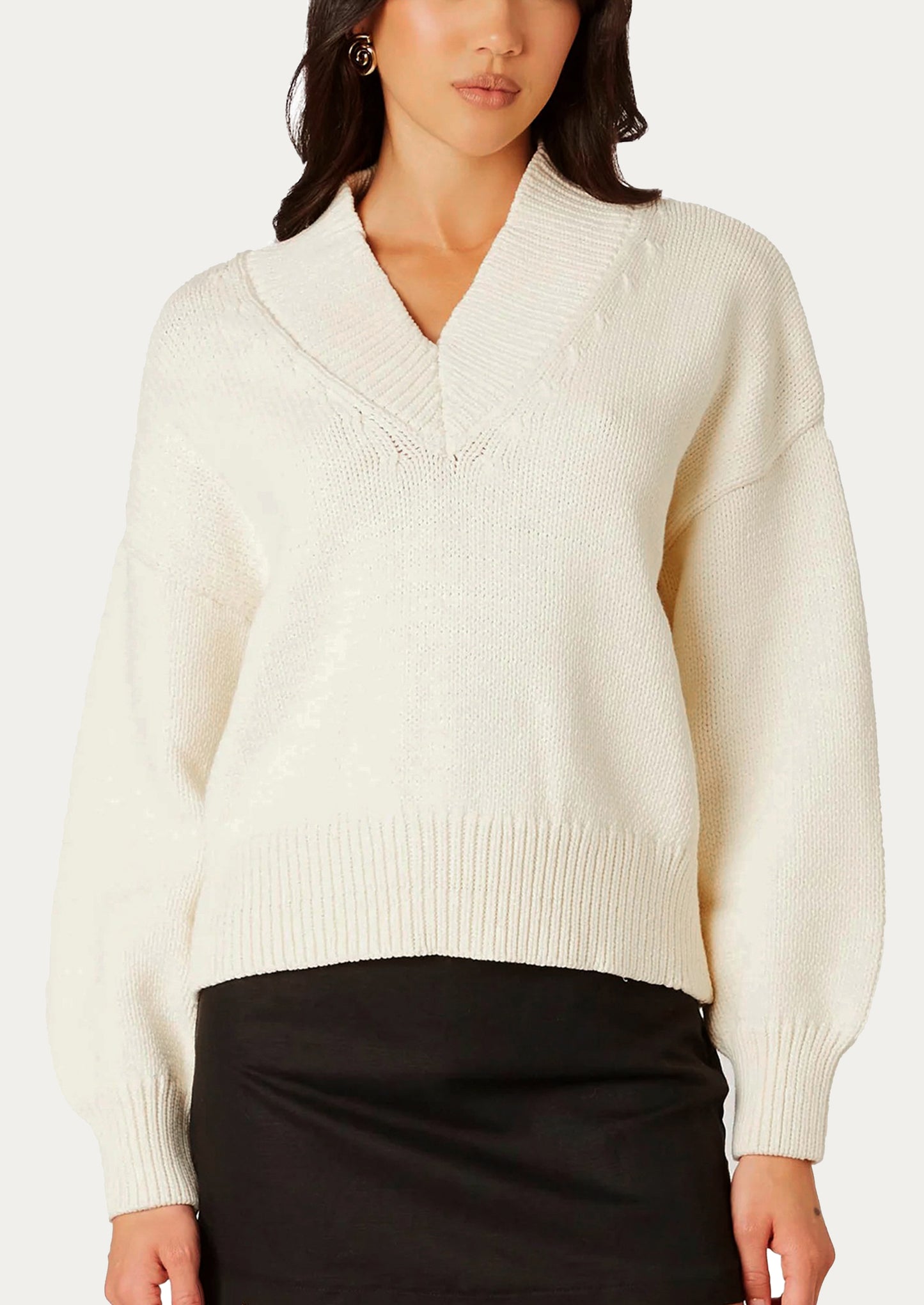 Woman wearing a cream sweater against a white background