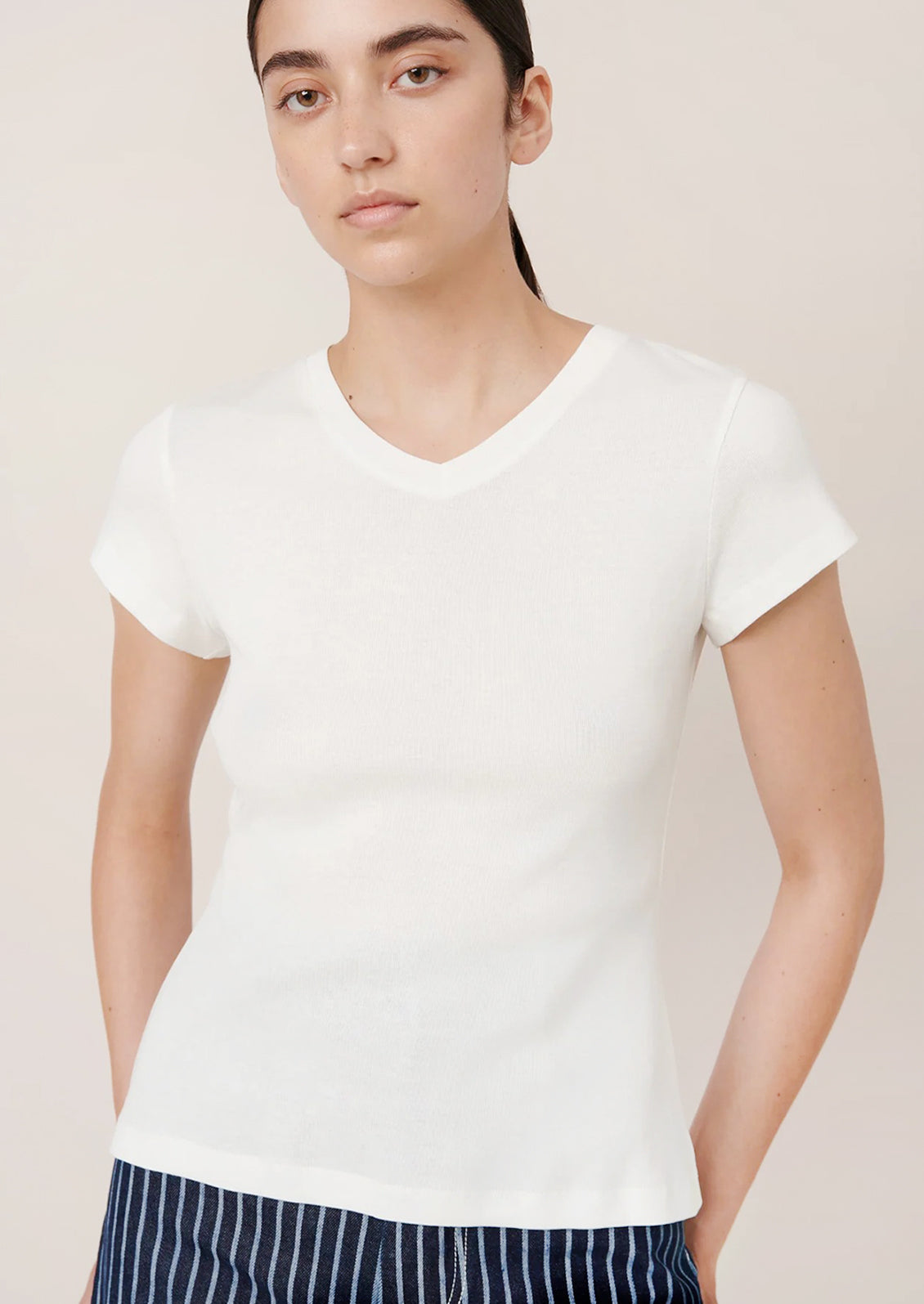Person wearing a white t-shirt against a plain background