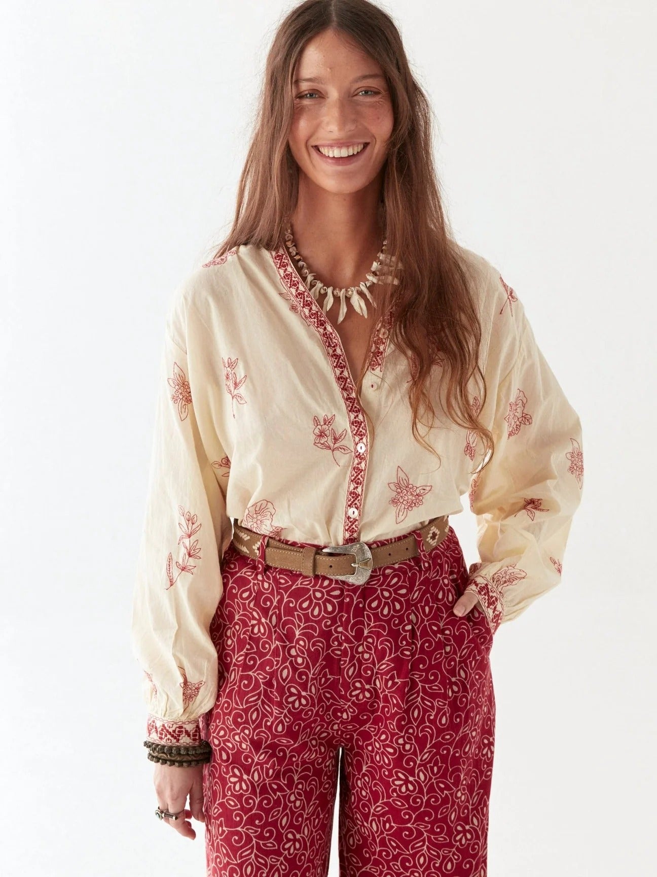A person wearing a pair of red paisley patterned pants.