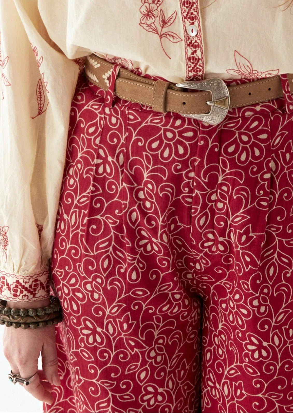 A person wearing a pair of red paisley patterned pants.
