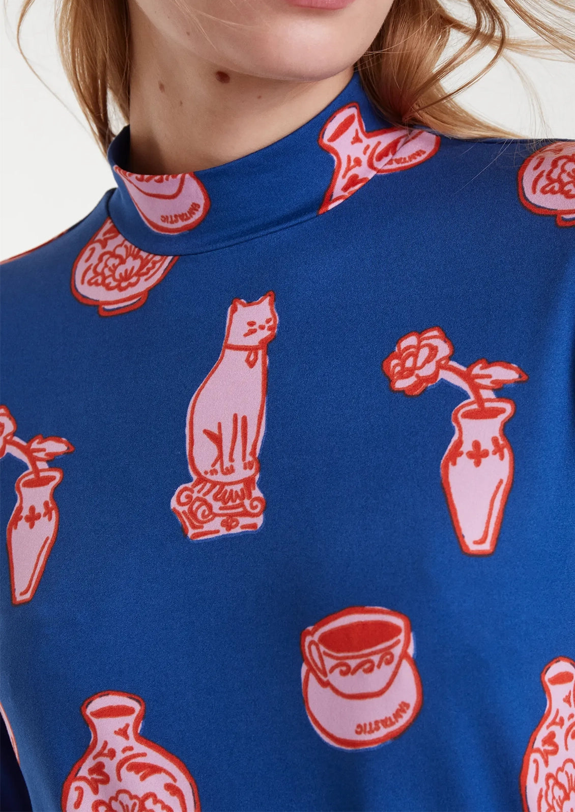 Blue long-sleeve shirt with red and pink ceramics pattern.