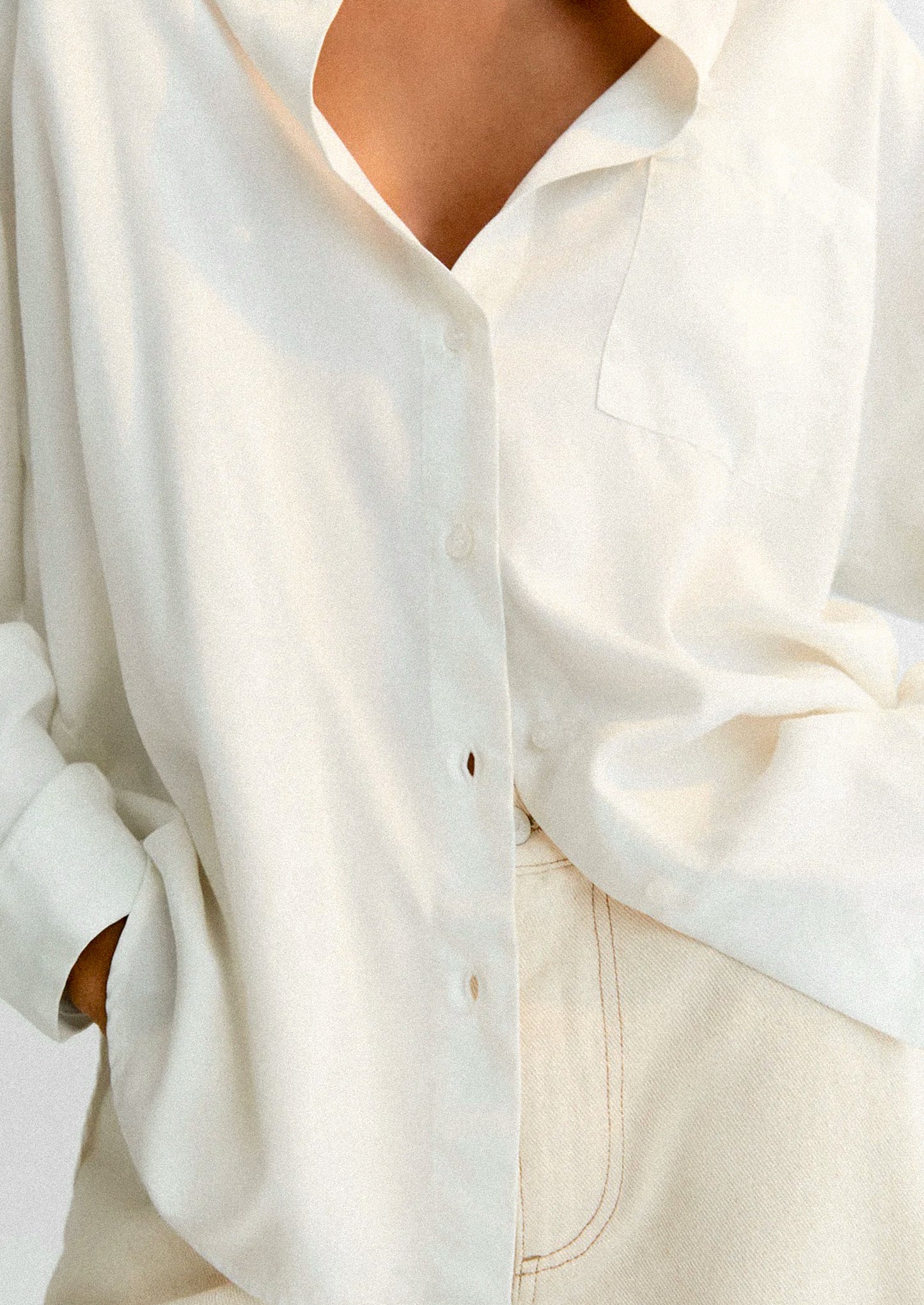 A close-up of a person wearing a white button front shirt.