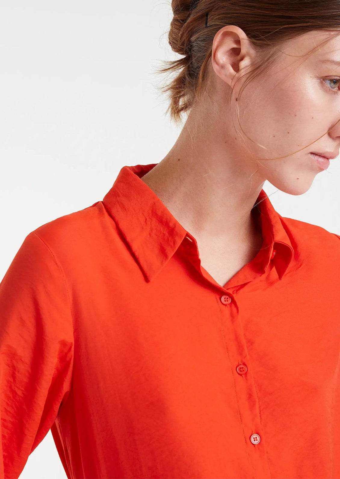 A vibrant red-orange button up collared shirt in silky textured fabric.