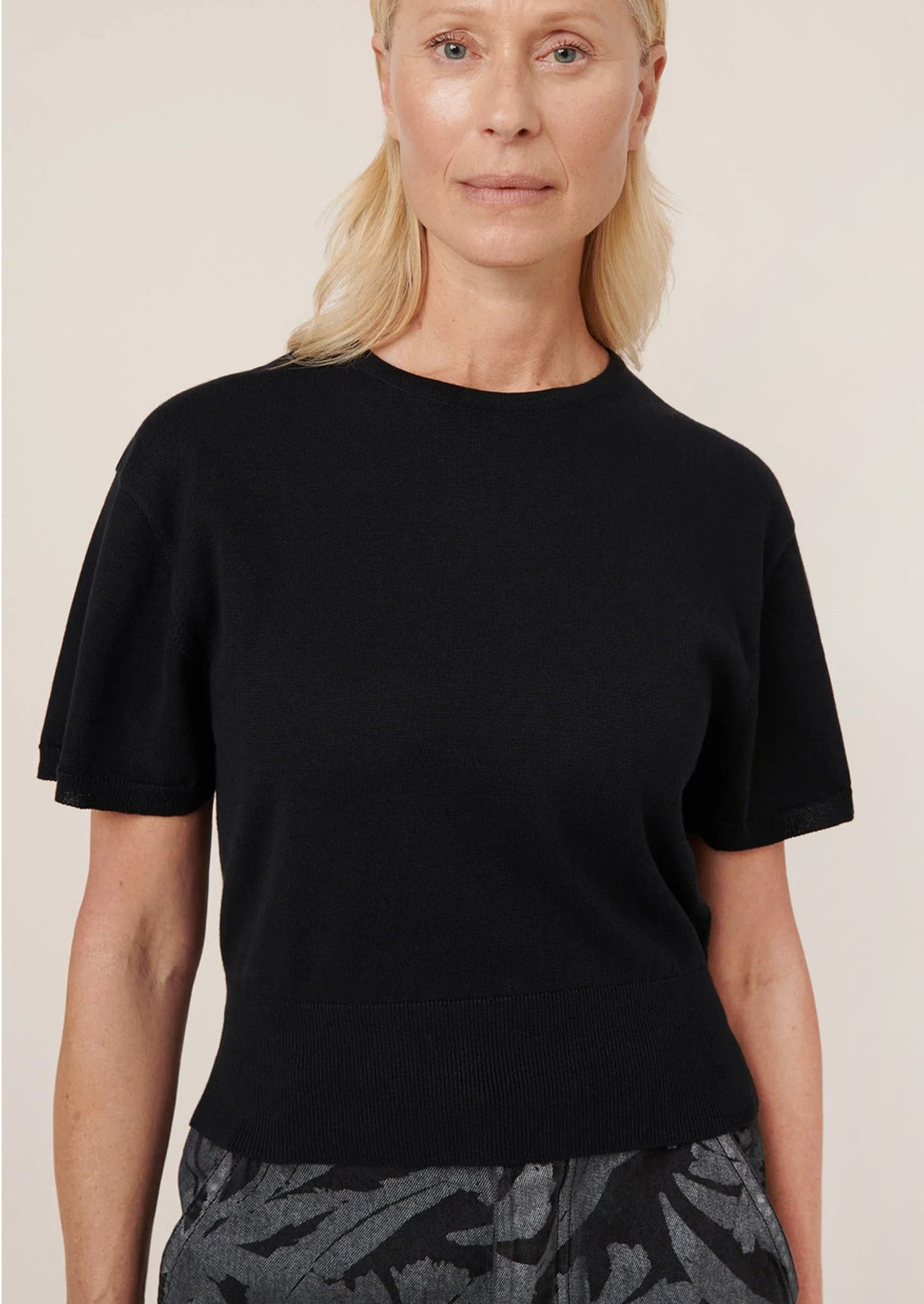 Woman wearing a black t-shirt against a plain background
