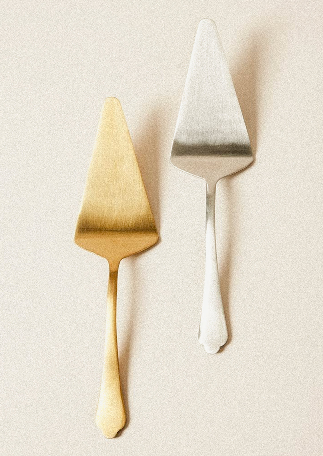 Stainless steel cake servers in gold and silver.