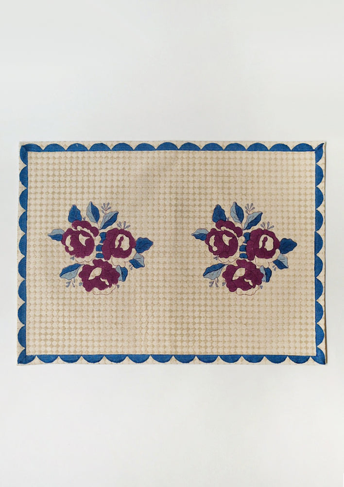 A block printed placemat in wine, blue and beige color palette.