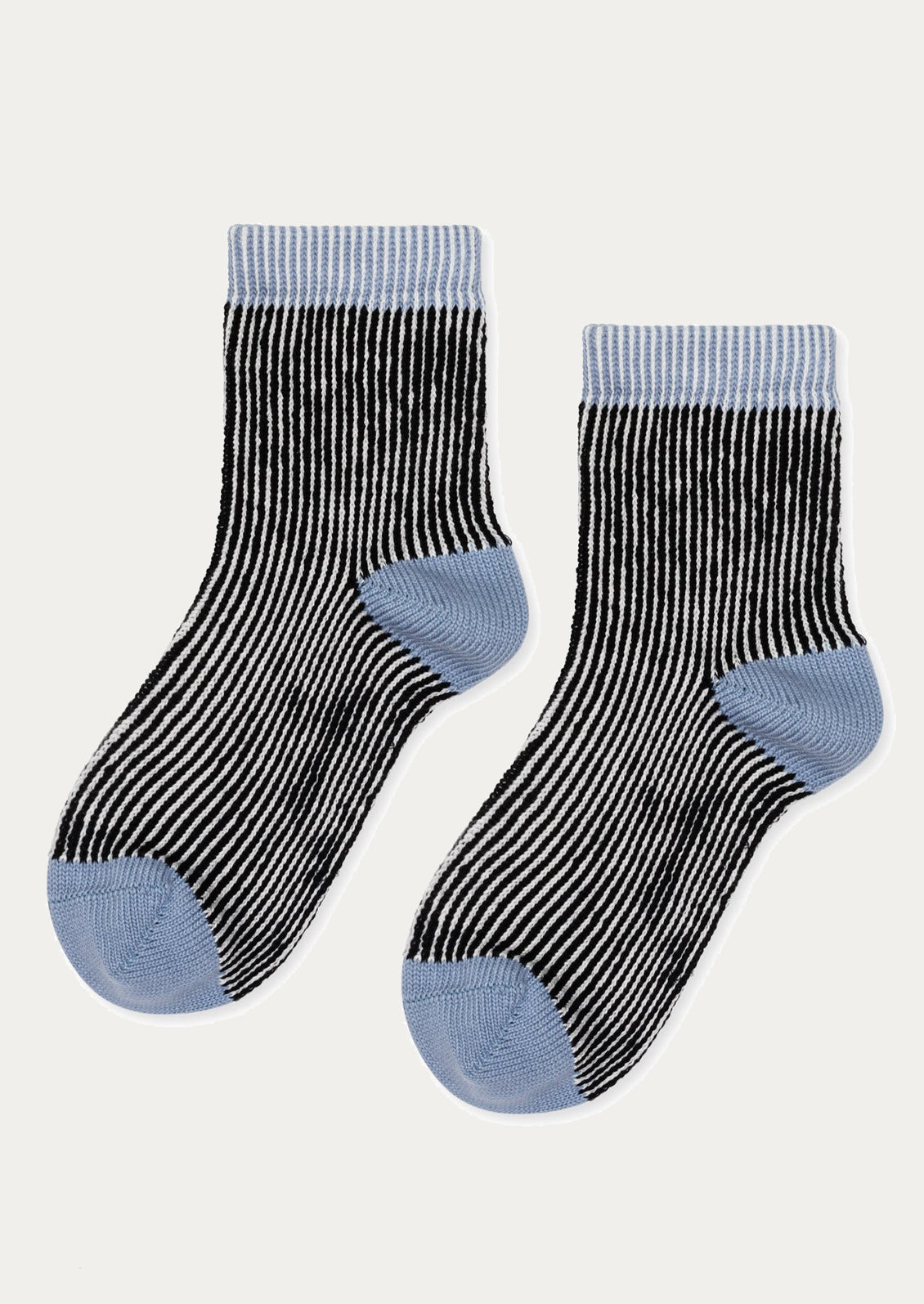 Pair of black and white striped socks with blue accents on a light gray background
