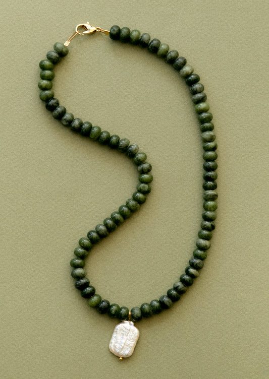 A  necklace with jade beads and pearl pendant.