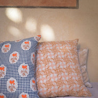 2: A block printed lumbar pillow with navy diamond checker and orange floral pattern.