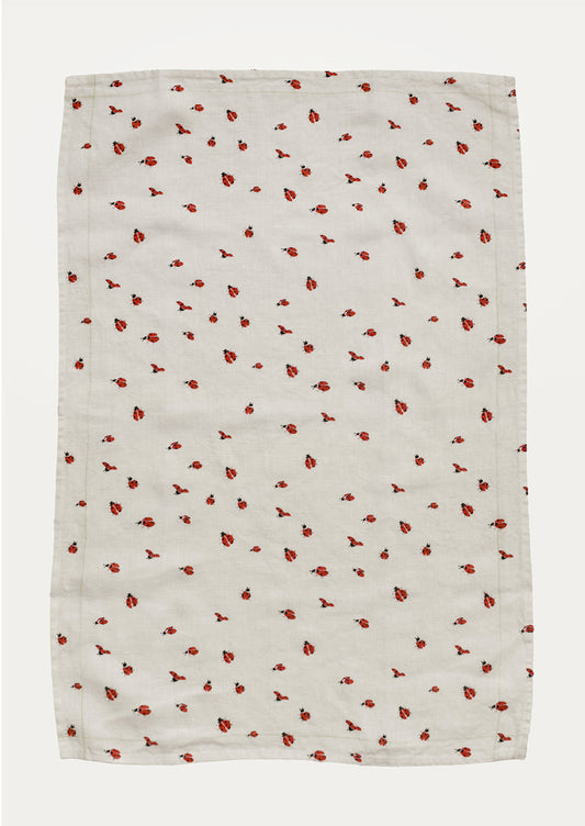 White towel with red ladybug pattern on a white background