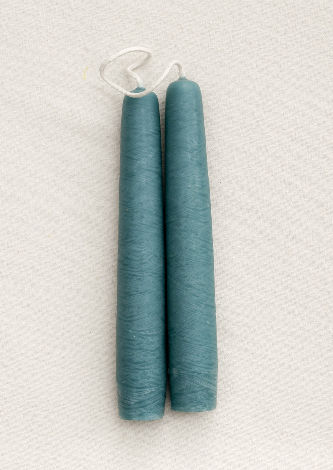 A pair of short taper candles in shade Lake Blue.