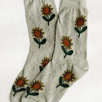 1: A pair of seafoam colored socks with sunflower pattern.