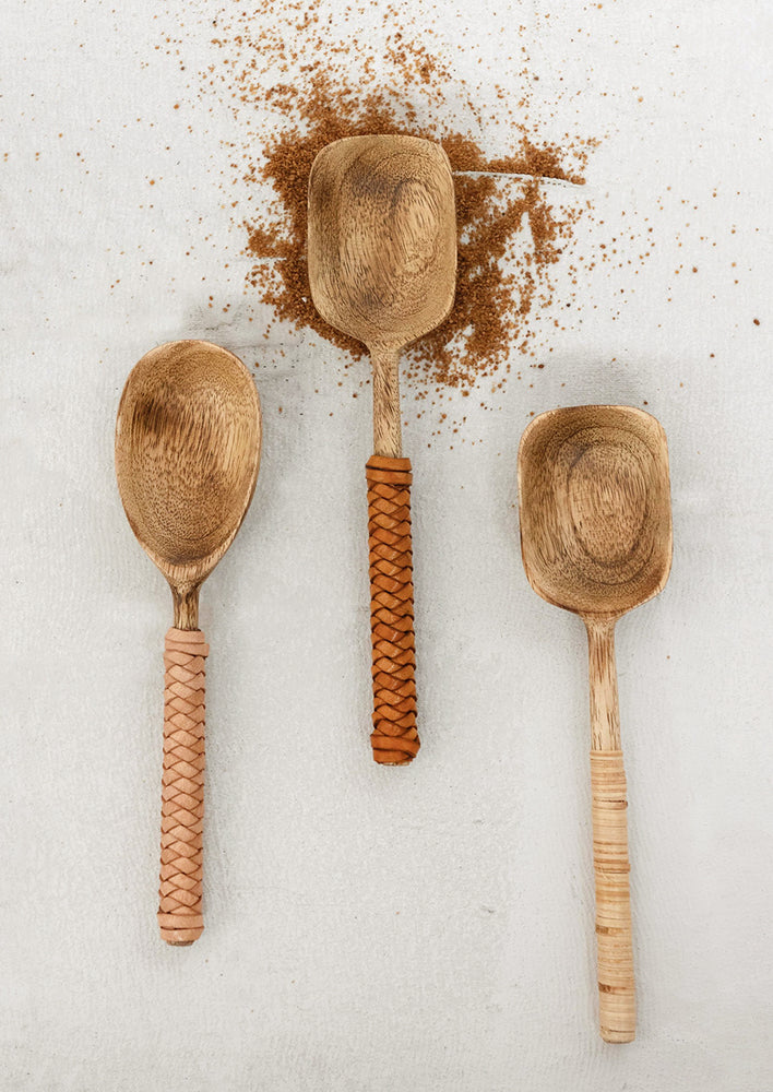 Wooden spoons with leather and rattan wrapped handles.