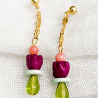 2: A pair of drop earrings with gold chain and beads.
