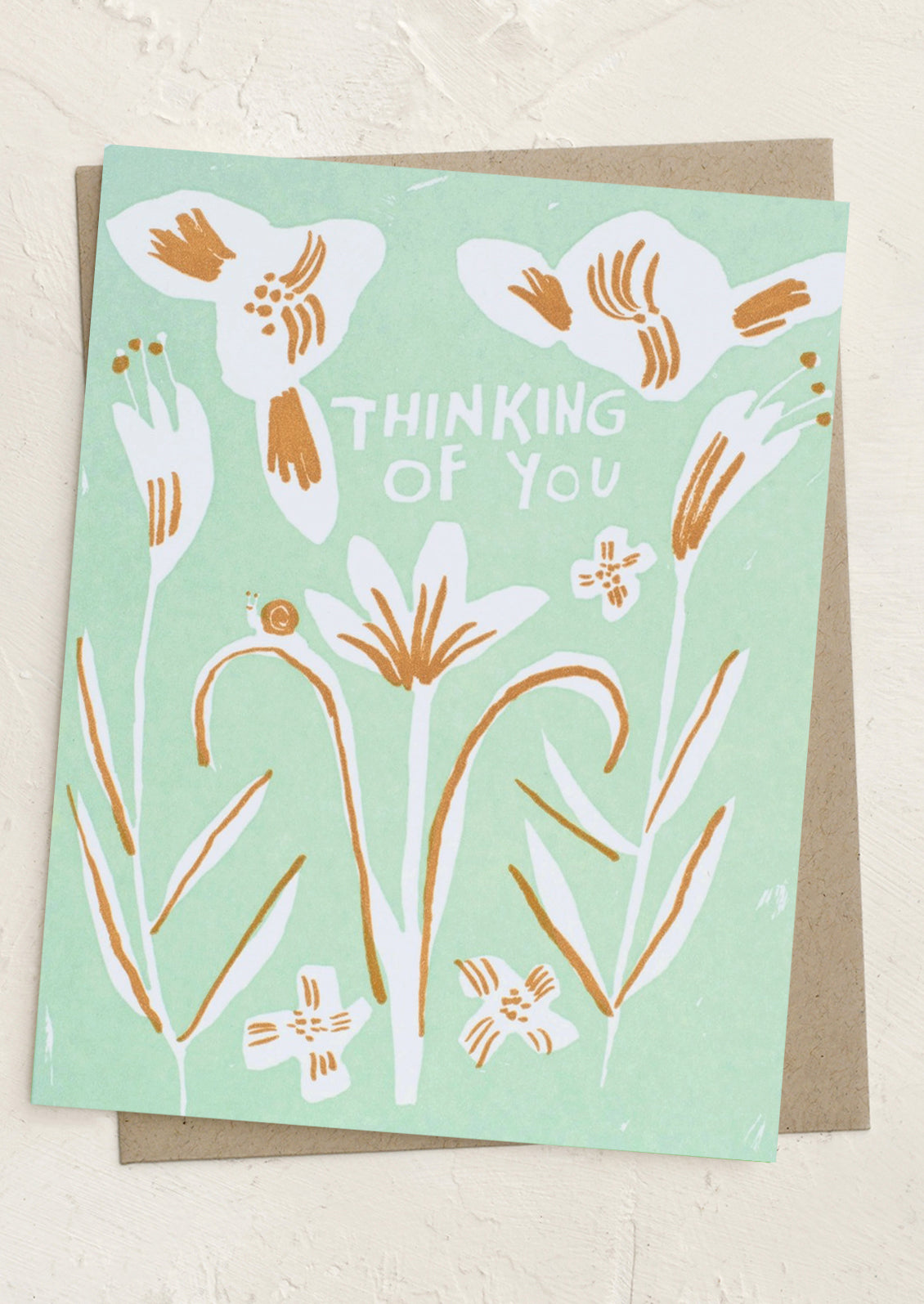 Greeting card with floral design and 'Thinking of You' text on a light green background