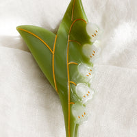 1: A hair claw in the shape of lily of the valley plant.