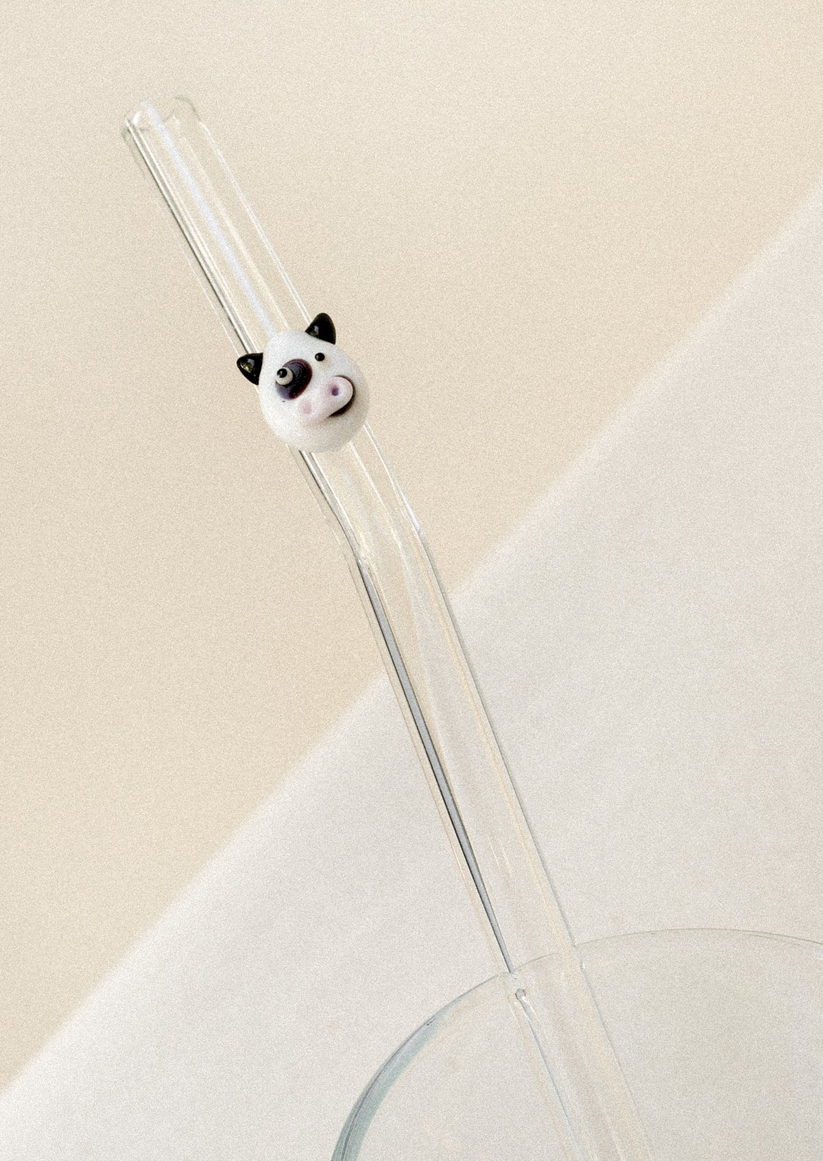 A glass straw with a cow face on it.