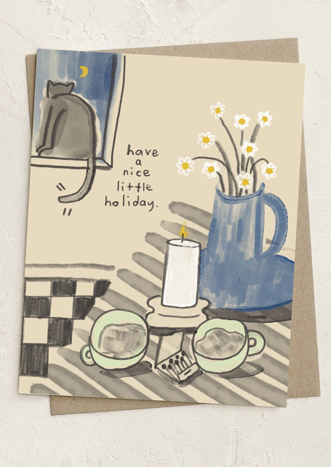 Greeting card with a cat, candle, and flowers on a checkered tablecloth.
