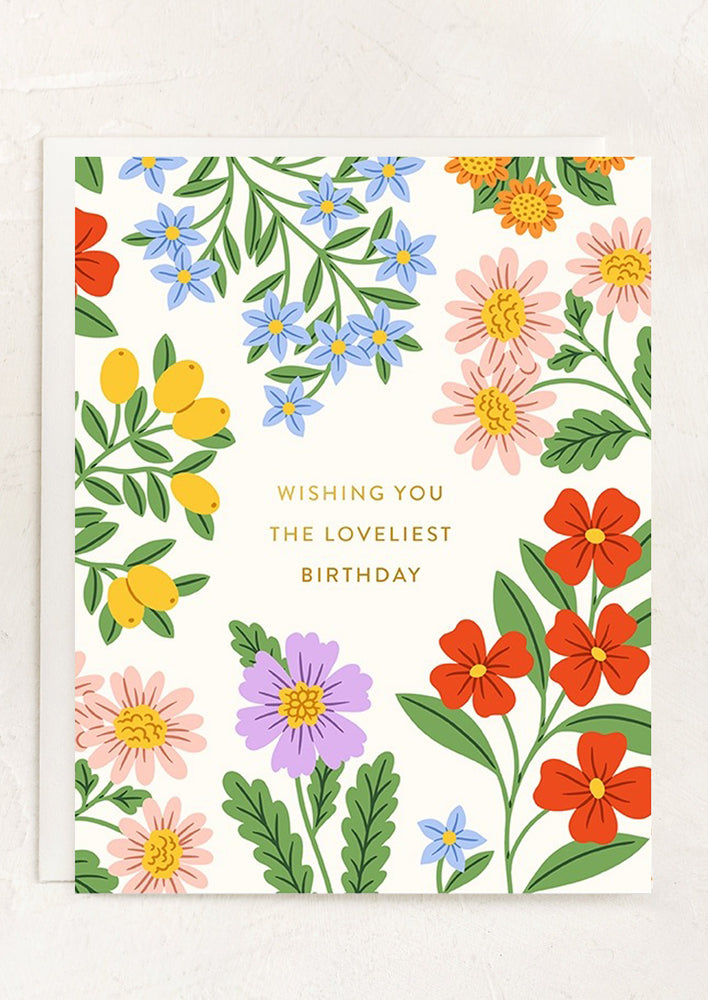 A card with colorful flower print, text reads "Wishing you the loveliest birthday".