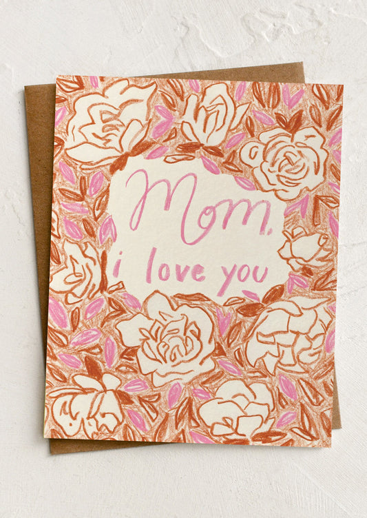 Greeting card with floral design and 'Mom, I love you' text on a textured surface