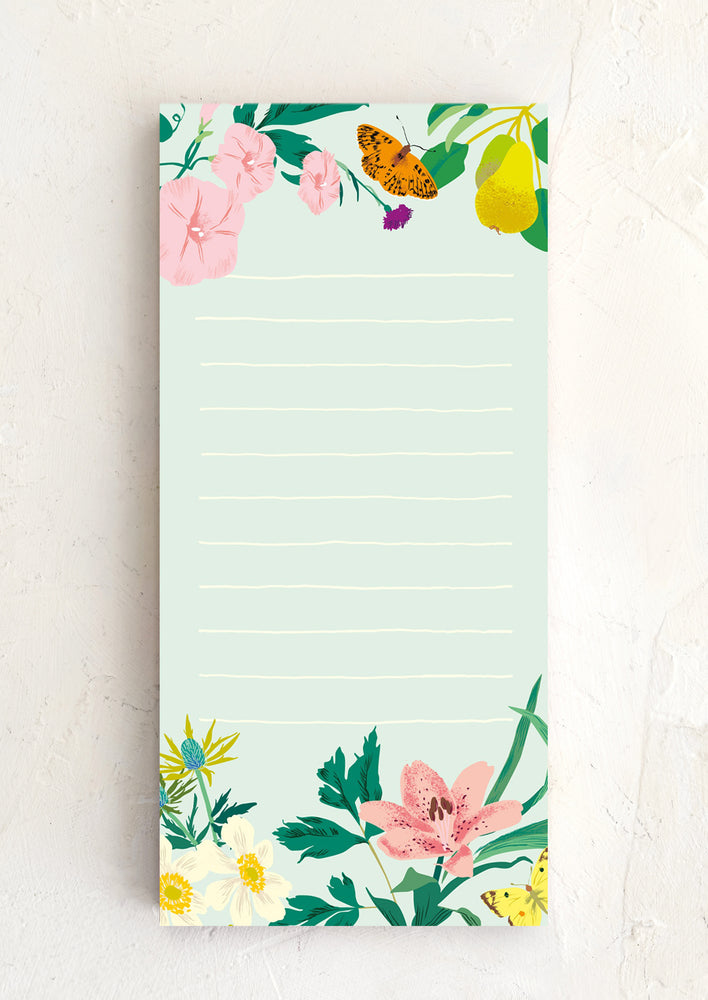 A mint colored notepad with floral and butterfly pattern.