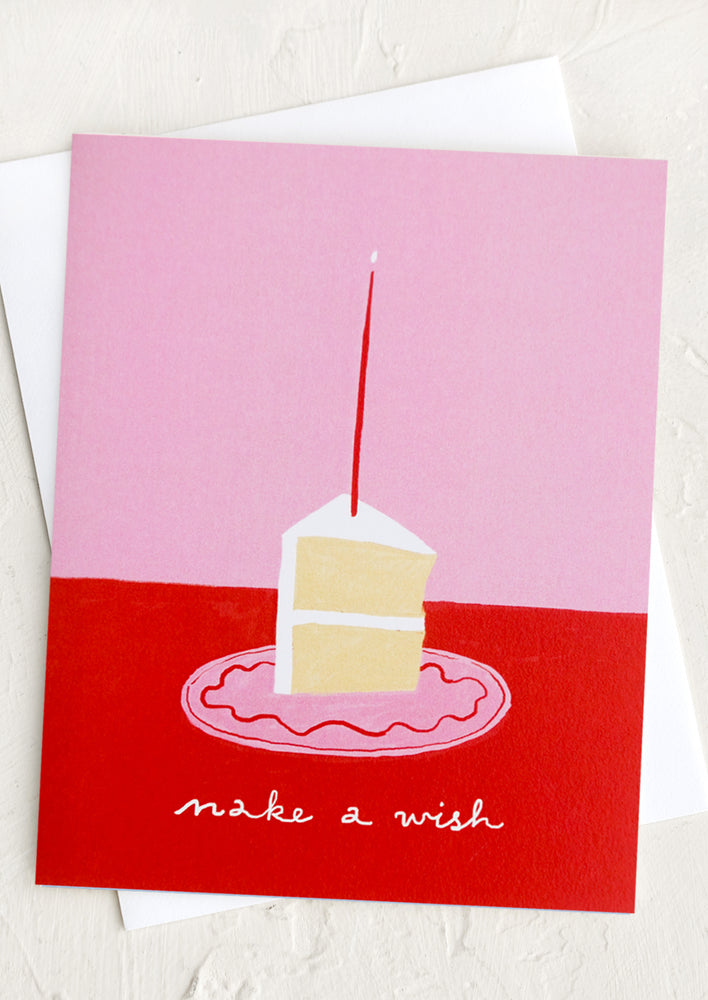 An illustrated card with image of vanilla cake slice with candle, text reads "Make a wish".