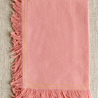 Peony: A pink tea towel with yellow stitching.