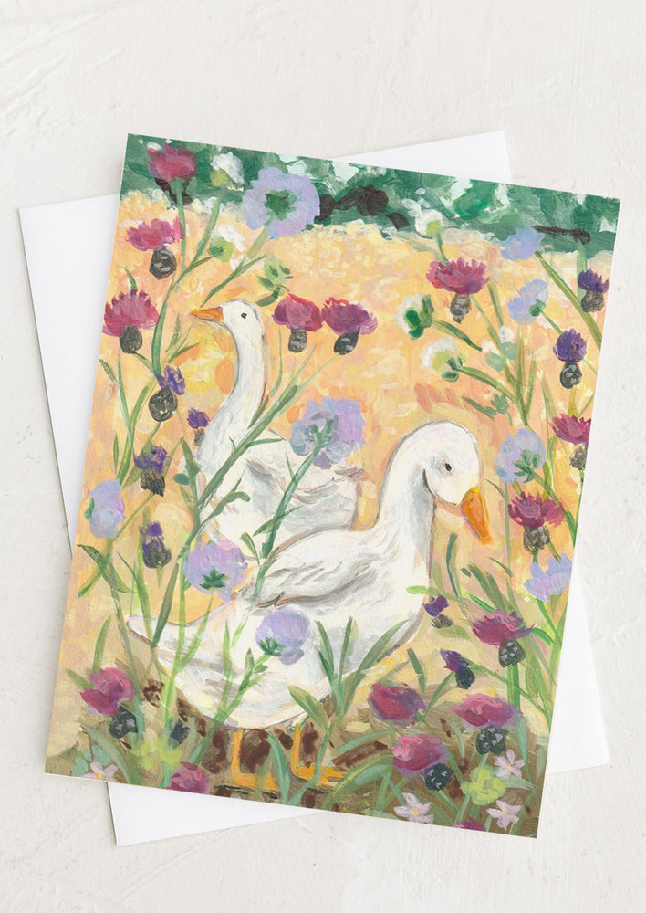 A greeting card with illustration of two ducks in a meadow.
