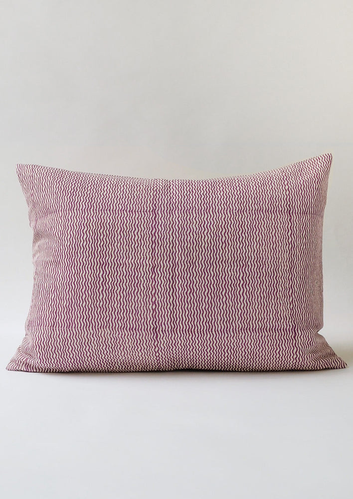A lumbar throw pillow with wavy purple lines.