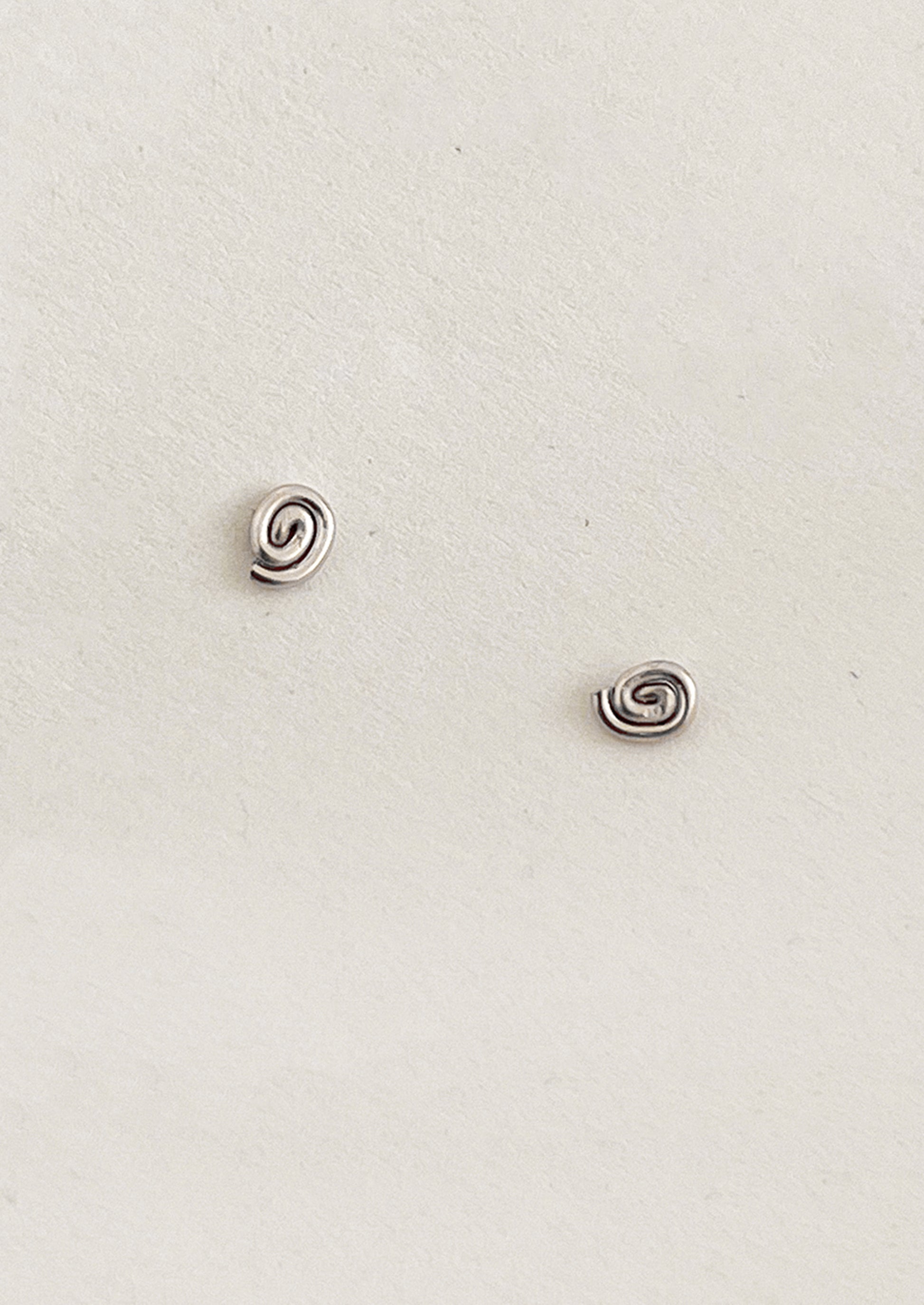 Pair of silver spiral earrings on a light gray background