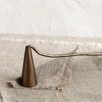 3: A metal candle wick snuffer with curved handle and tapered shape.