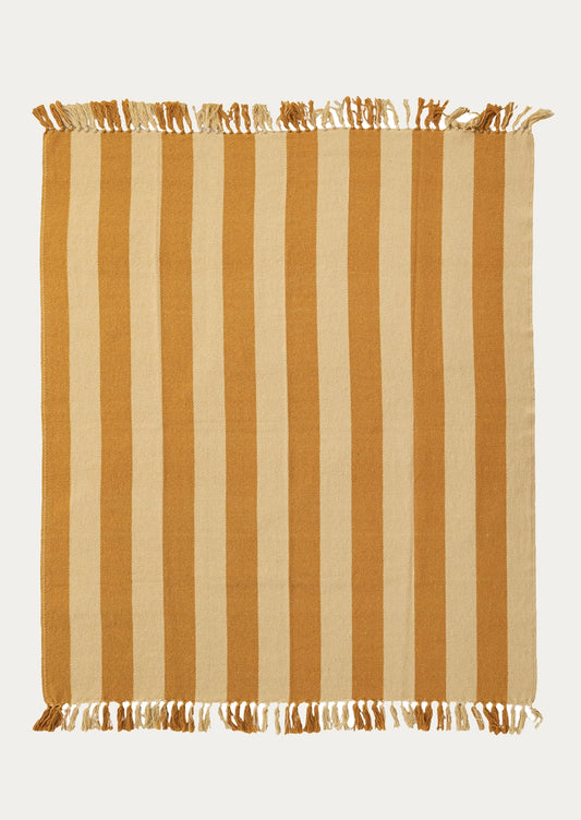 A throw blanket with vertical mustard and pale yellow stripes and fringed edges.