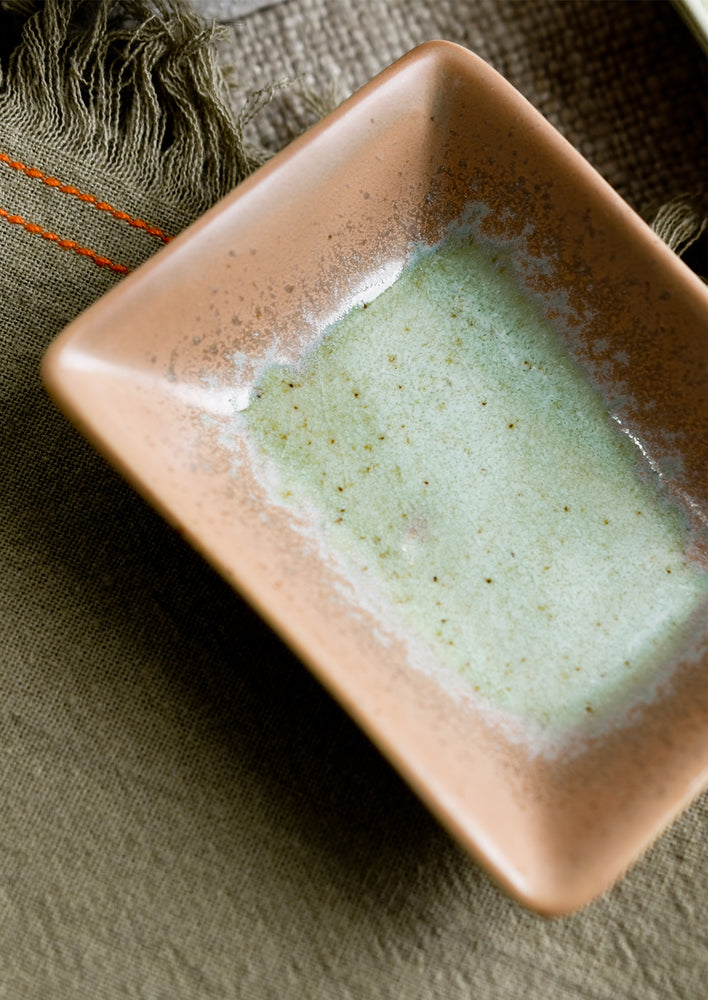 Rectangular ceramic sauce dishes in turquoise, green and brown varied glazes.