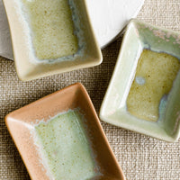 1: Rectangular ceramic sauce dishes in turquoise, green and brown varied glazes.