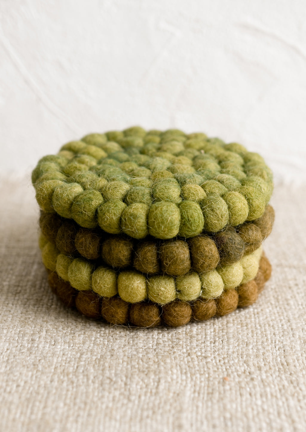3: A set of felted ball coasters in mixed tones of green.