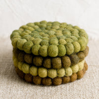 3: A set of felted ball coasters in mixed tones of green.