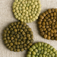 4: A set of felted ball coasters in mixed tones of green.