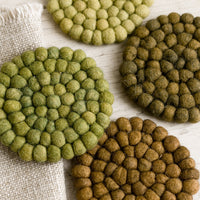 1: A set of felted ball coasters in mixed tones of green.