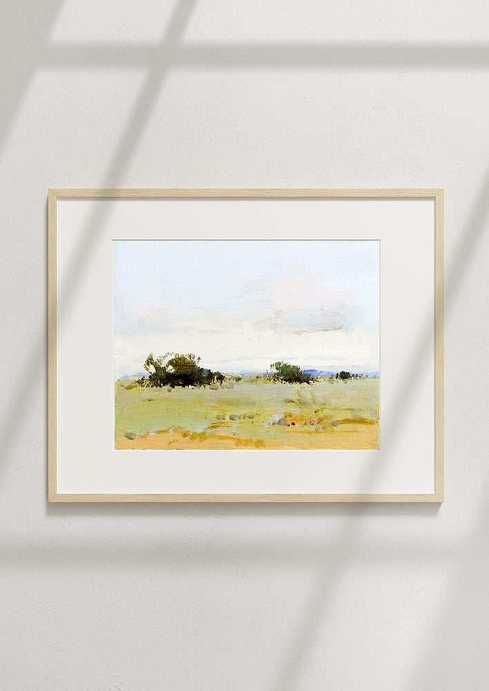 A framed landscape oil painting.