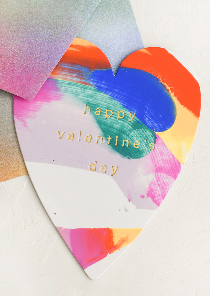 A heart-shaped greeting card with multicolor paint design, reads "Happy Valentine's day".