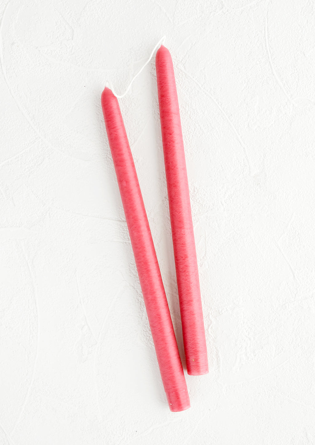Raspberry: A pair of taper candles in raspberry pink.