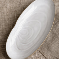 Serving Platter: A ceramic serving platter in shape of a shell.