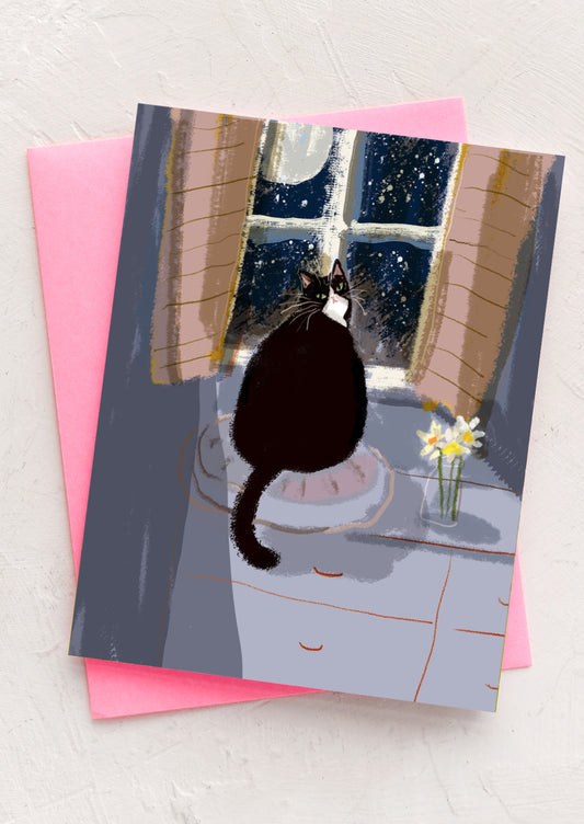 An illustrated greeting card of a cat sitting at a window with the moon outside.