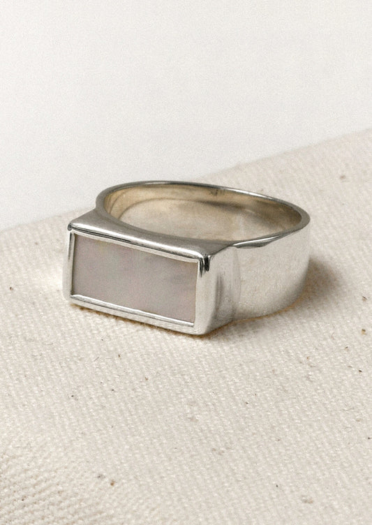 A sterling silver ring with a thick band and a rectangular mother of pearl set in the center.