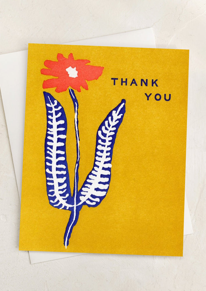 A yellow red and blue flower print card reading "Thank you".