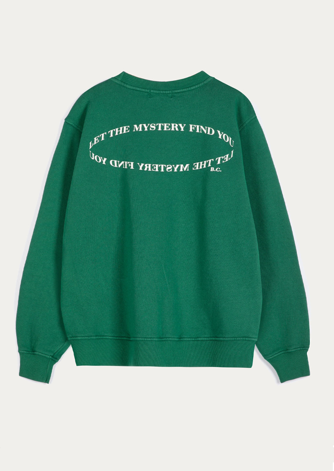 A green crewneck sweatshirt shown from the back, featuring white text printed in an arch across the upper back that reads 'LET THE MYSTERY FIND YOU'.